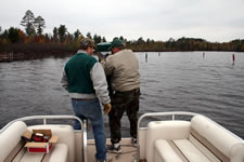 Twice every year; in the spring the channel markers are placed then they are taken out for the winter. Here are Cal Weck and Dan Carlson hauling in a marker - Click to enlarge.